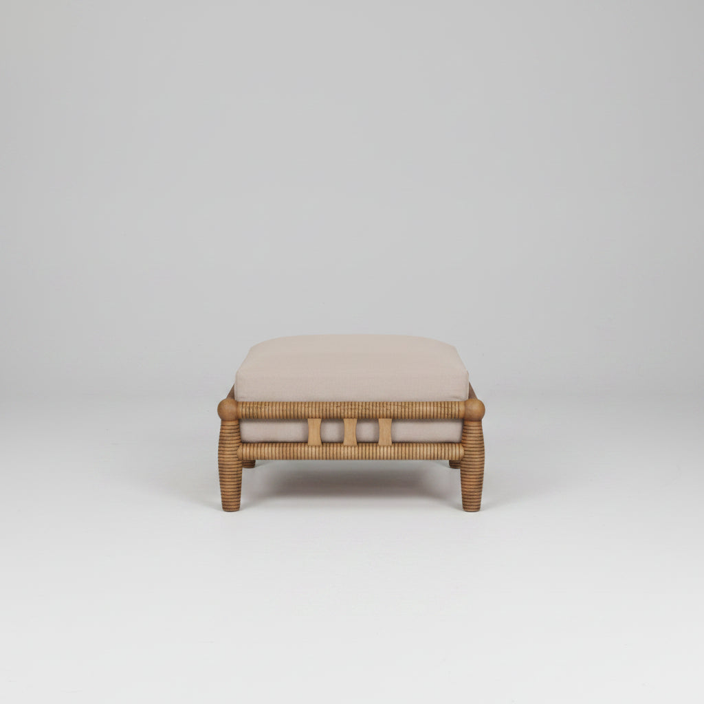 Wicker ottoman with a cushion on a white background