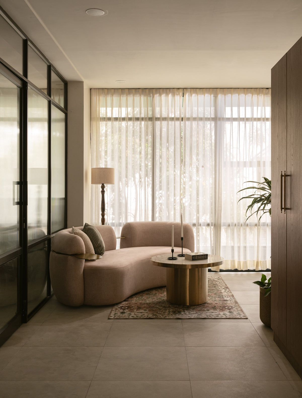 A curved couch and fluted coffee table in a quiet sitting room