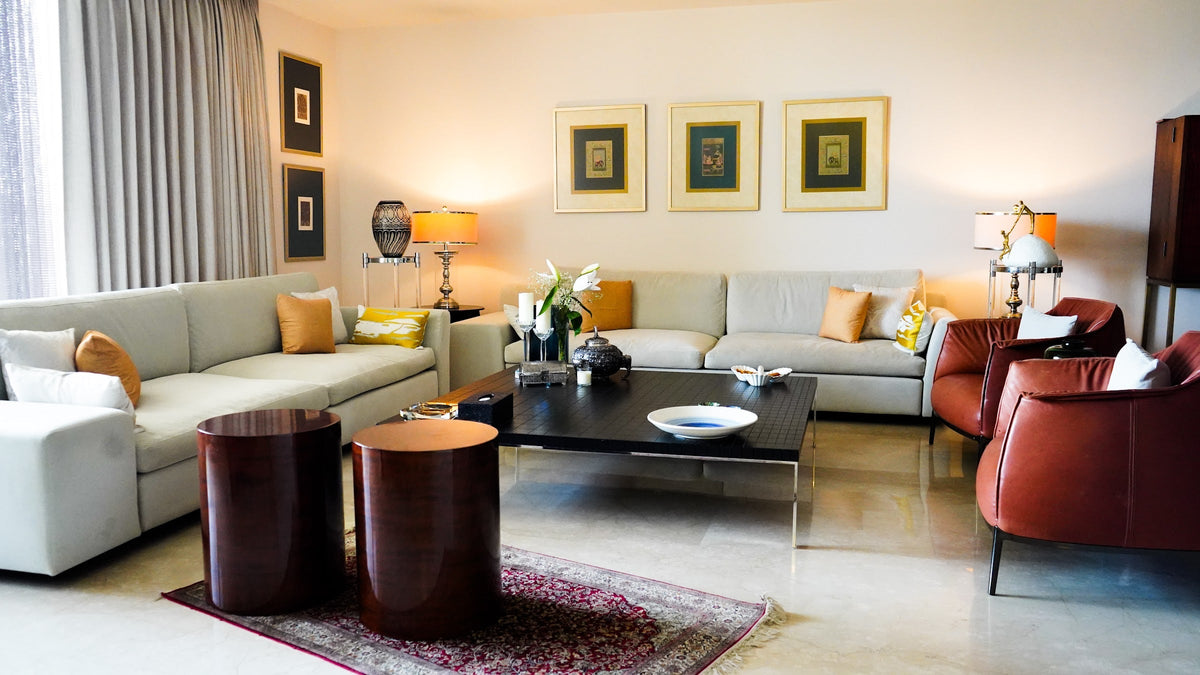 A sectional sofa, leather armchairs and drum side tables in a lounge